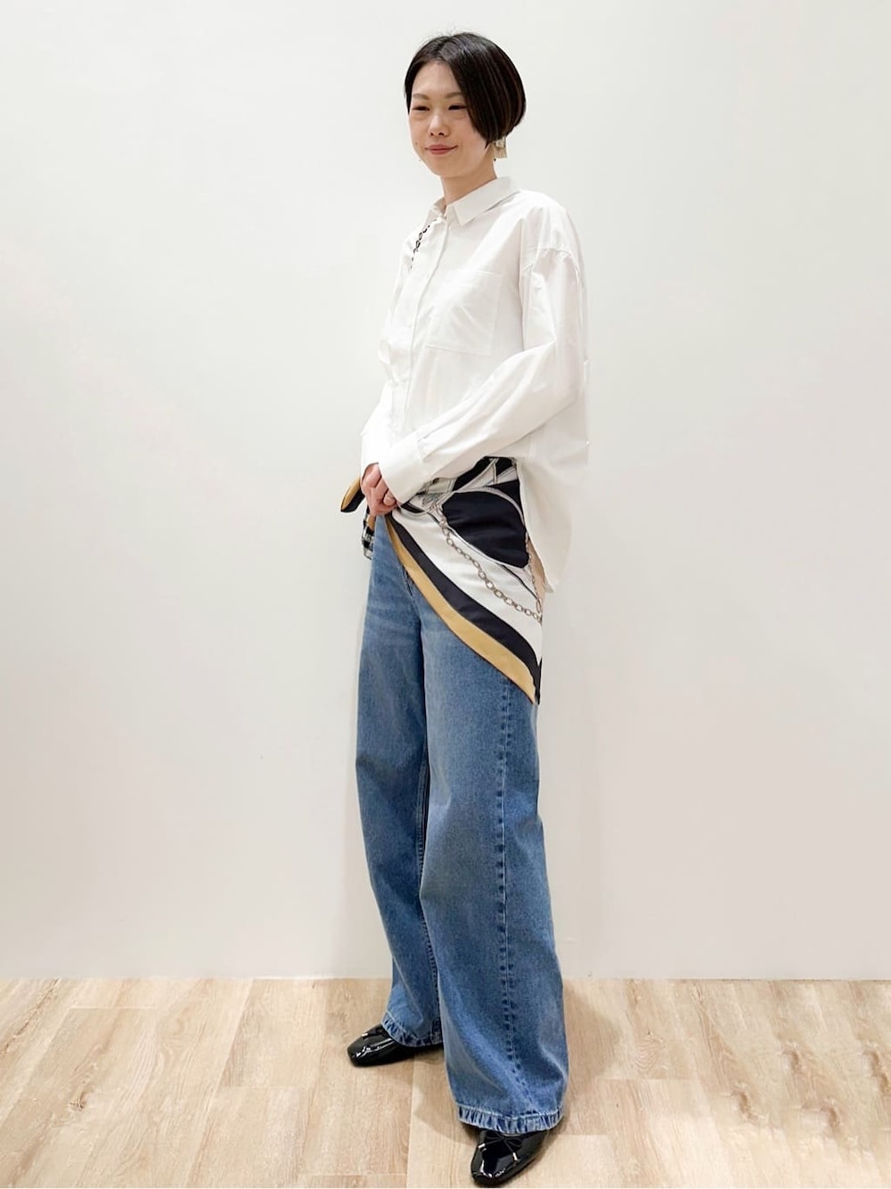 ブルー系のデニムパンツ、ブラック系のパンプス、ホワイト系のシャツ/ブラウスを着用したレディースの春コーディネートの2枚目の写真