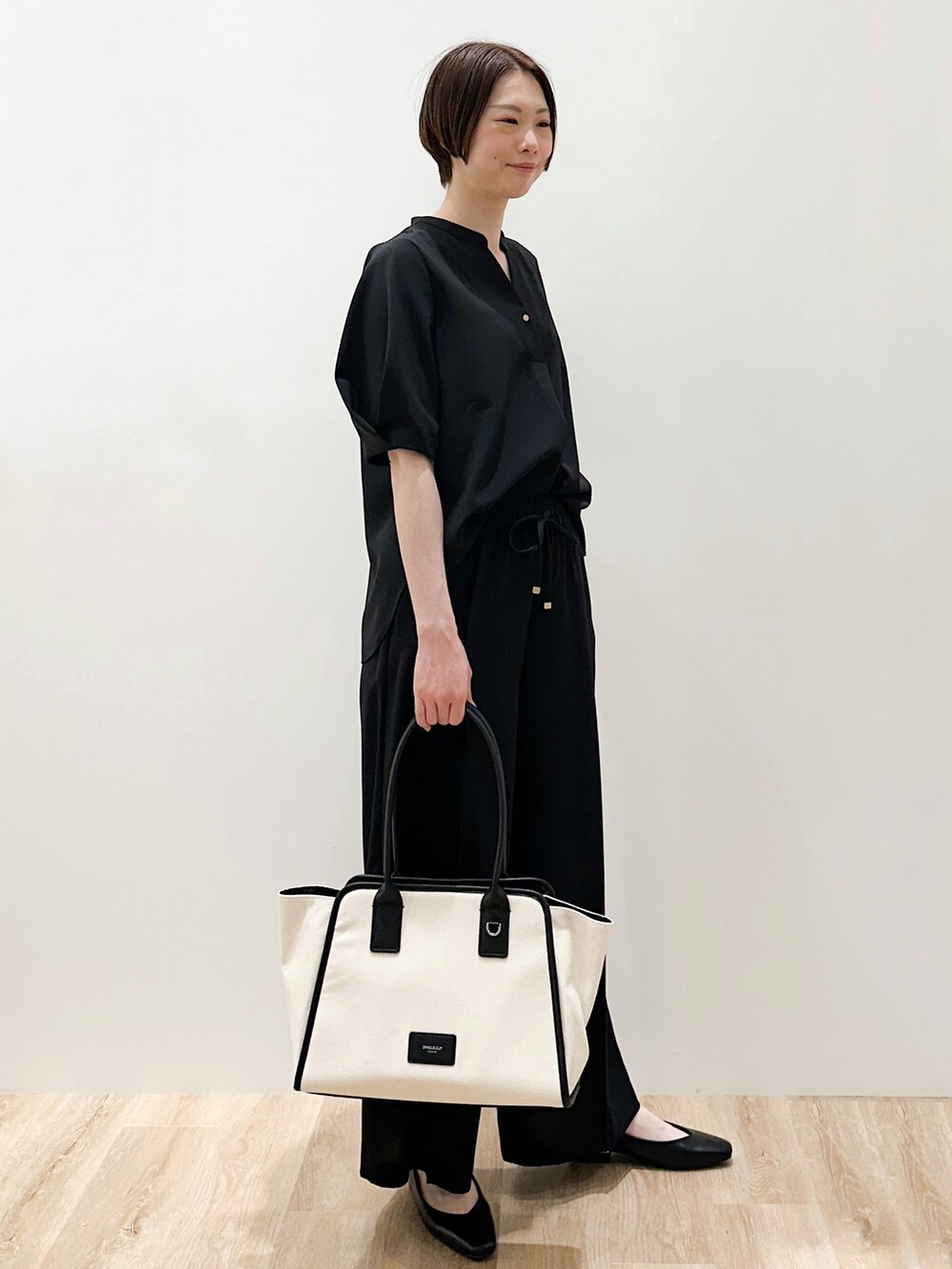 ブラック系のパンプス、ブラック系のシャツ/ブラウス、ブラック系のその他パンツを着用したレディースの春コーディネートの5枚目の写真