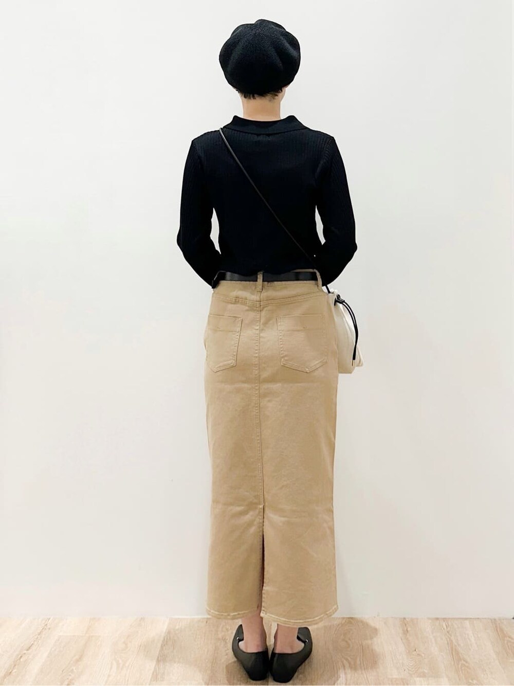 ブラック系のショルダーバッグ、ベージュ系のスカート、ブラック系のパンプスを着用したレディースの春コーディネートの3枚目の写真