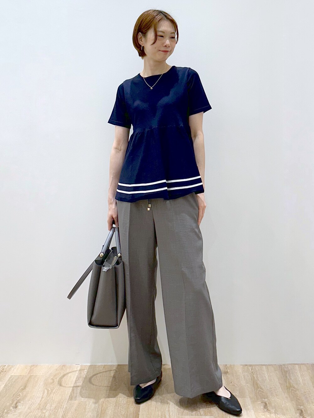 ブルー系のニット/セーター、グレー系のその他パンツ、グレー系のトートバッグを着用したレディースの夏コーディネートの5枚目の写真