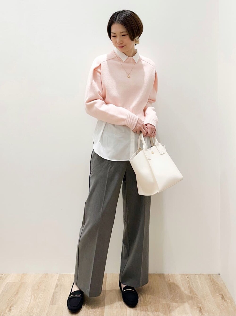 ピンク系のニット/セーター、ホワイト系のシャツ/ブラウス、グレー系のその他パンツを着用したレディースの冬コーディネートの2枚目の写真