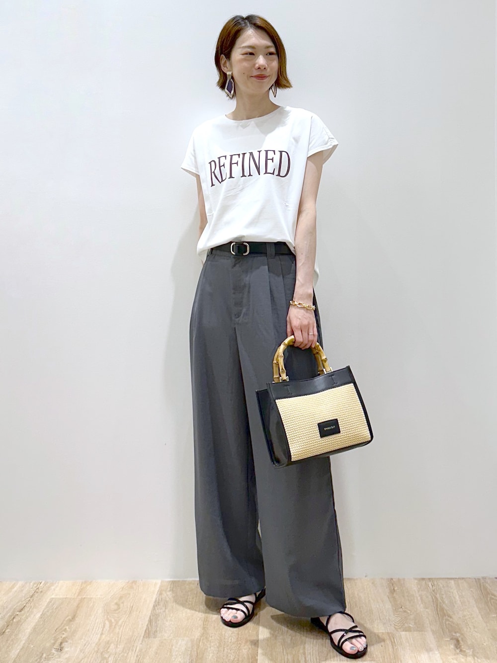 ホワイト系のTシャツ/カットソー、グレー系のその他パンツ、ブラック系のトートバッグを着用したレディースの夏コーディネートの3枚目の写真