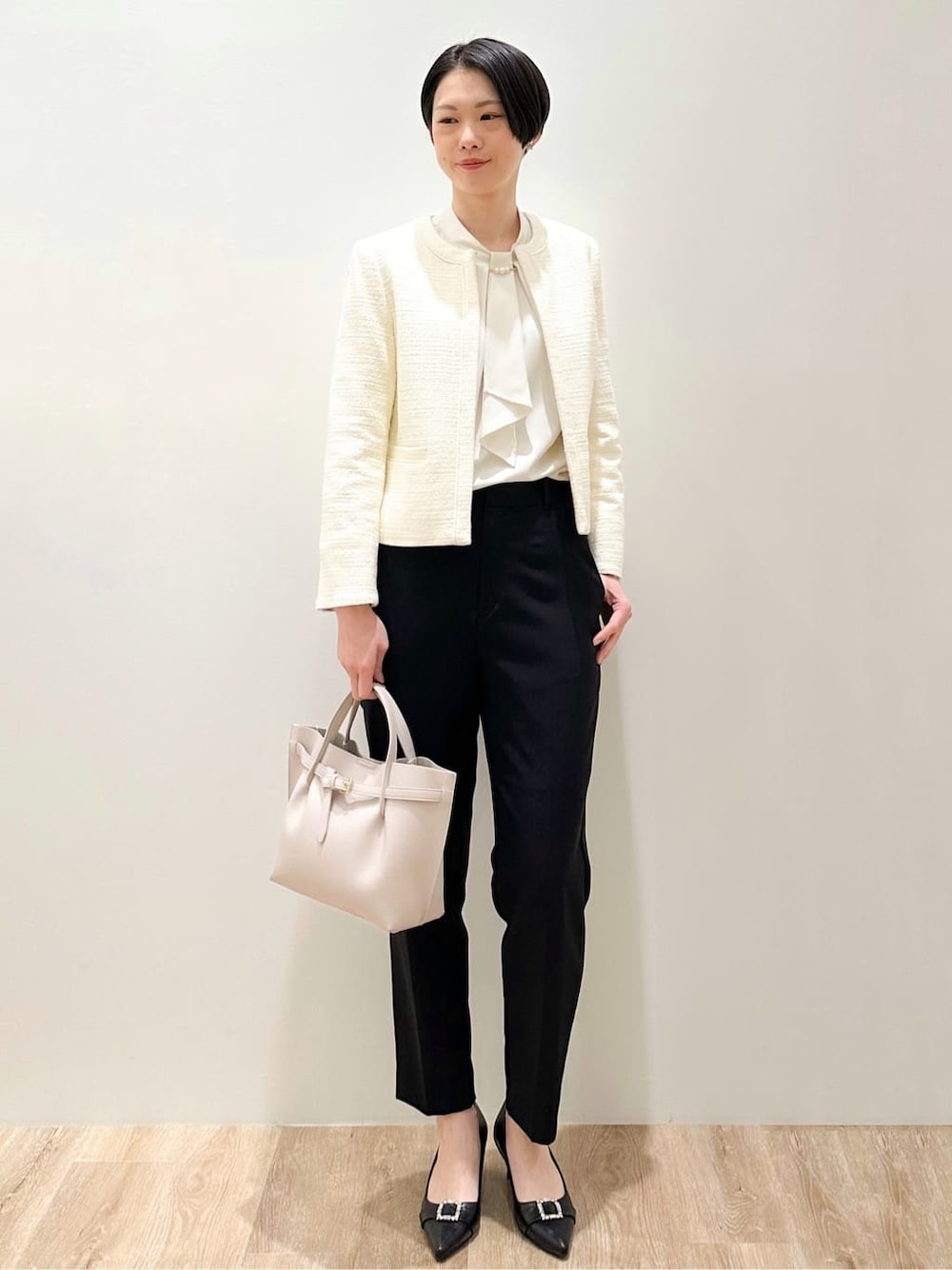 ピンク系のシャツ/ブラウス、ブラック系のその他パンツ、ホワイト系のノーカラージャケットを着用したレディースの冬コーディネートの2枚目の写真