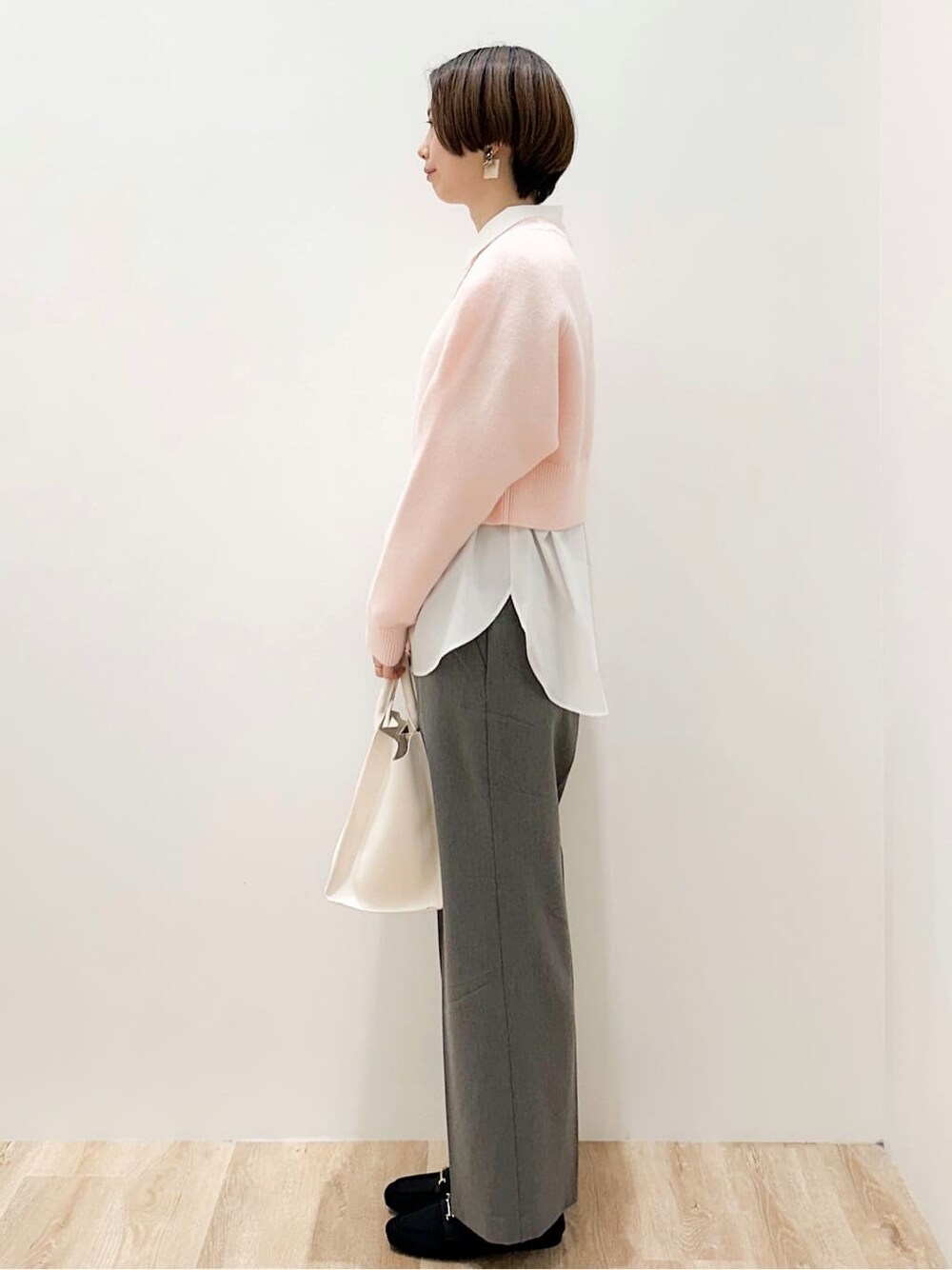 ピンク系のニット/セーター、ホワイト系のシャツ/ブラウス、グレー系のその他パンツを着用したレディースの冬コーディネートの5枚目の写真