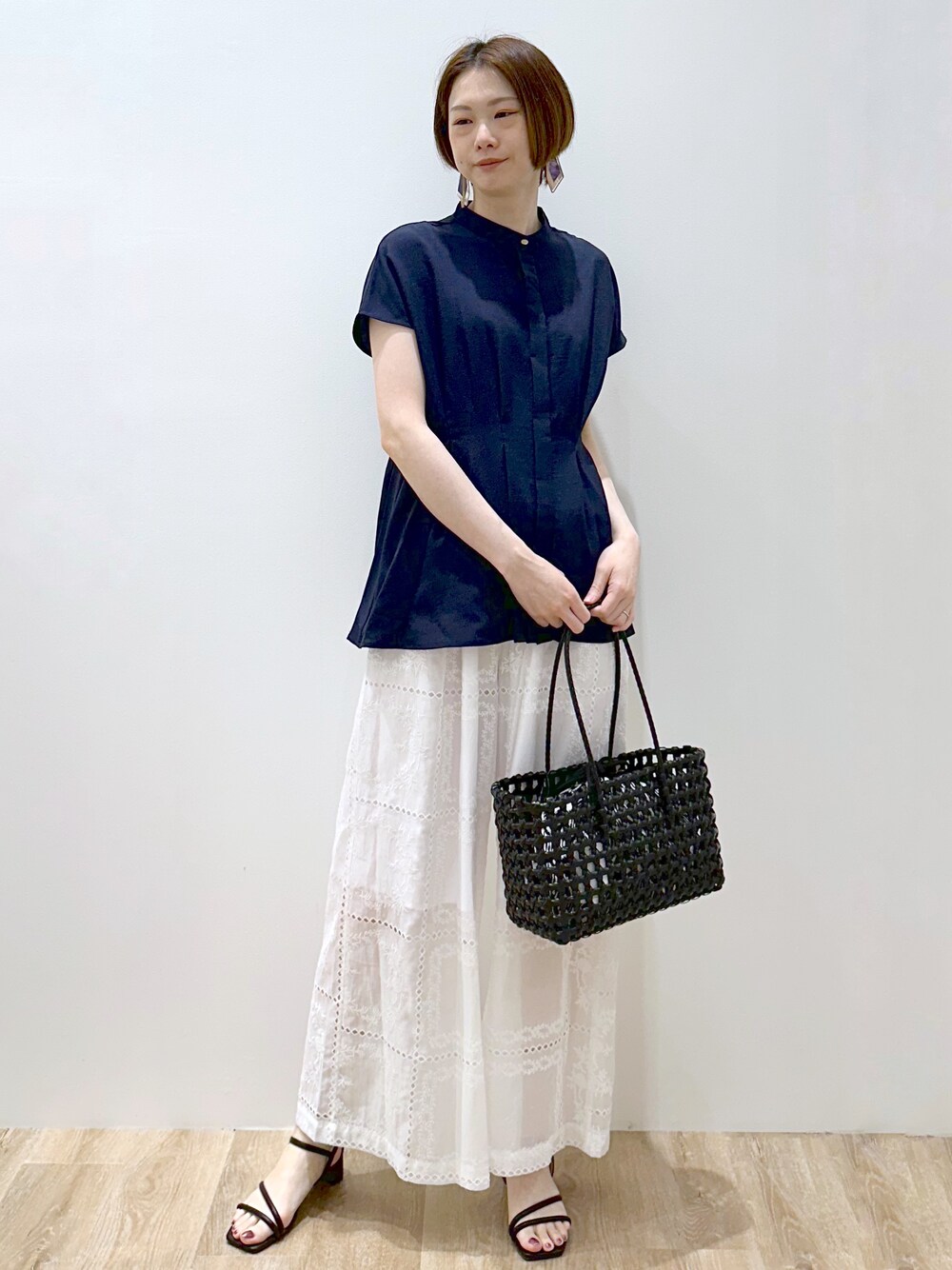 ブルー系のシャツ/ブラウス、ホワイト系のその他パンツ、ブラック系のトートバッグを着用したレディースの春コーディネートの4枚目の写真
