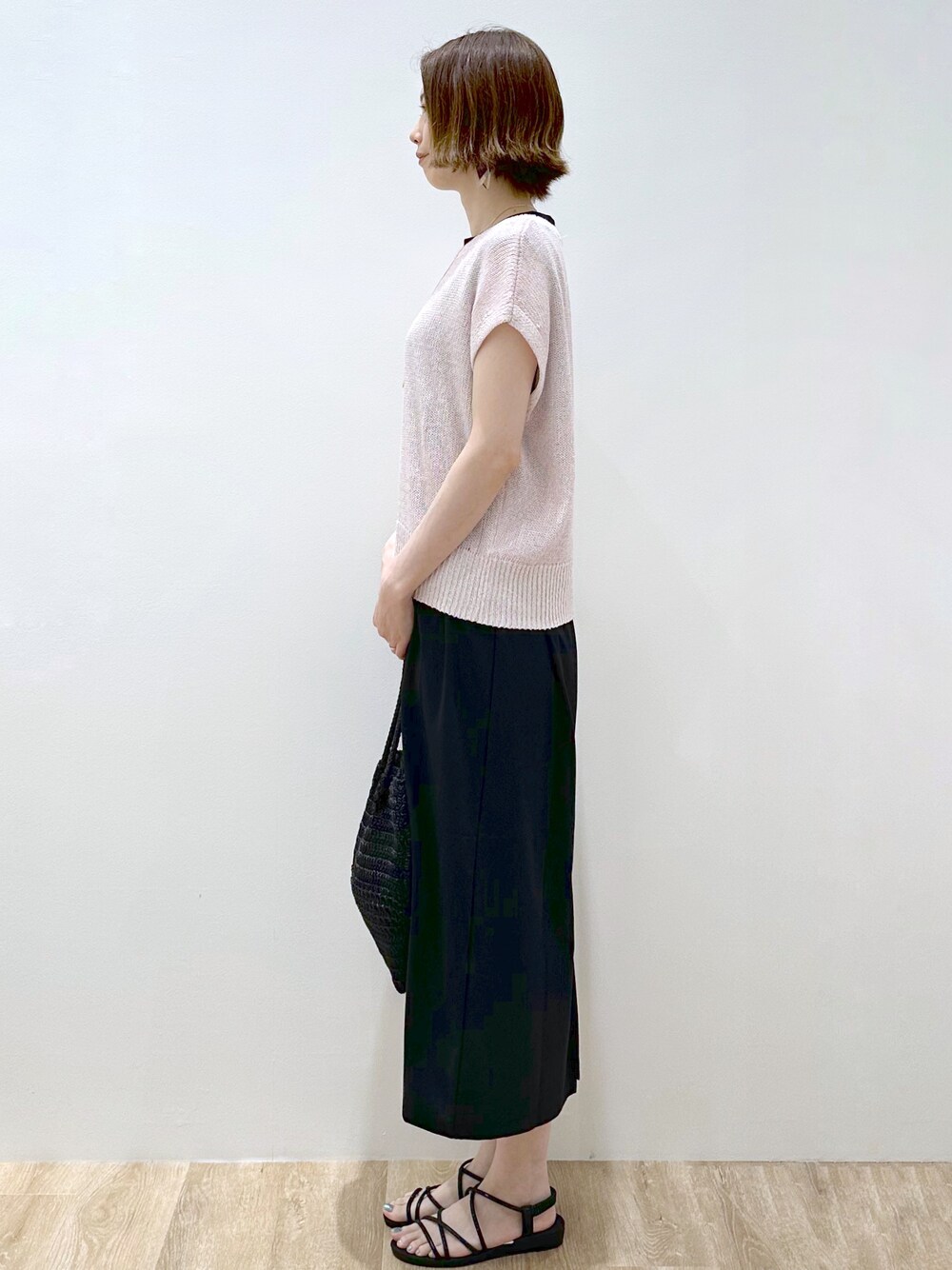 ピンク系のニット/セーター、ブラック系のトートバッグ、ブラック系のサンダルを着用したレディースの夏コーディネートの3枚目の写真
