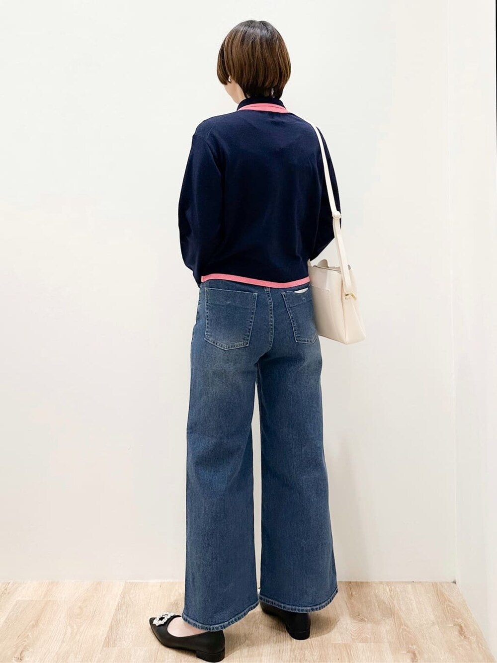 ブルー系のニット/セーター、ブルー系のデニムパンツ、ホワイト系のショルダーバッグを着用したレディースの冬コーディネートの3枚目の写真