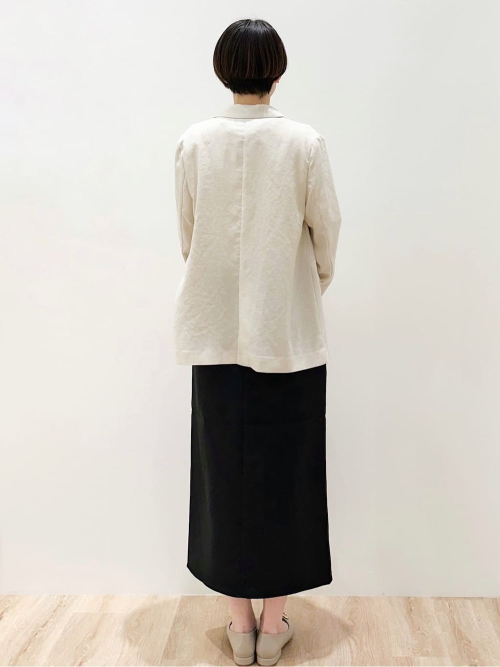 ベージュ系のパンプス、ブラック系のスカート、ベージュ系のトートバッグを着用したレディースの春コーディネートの3枚目の写真
