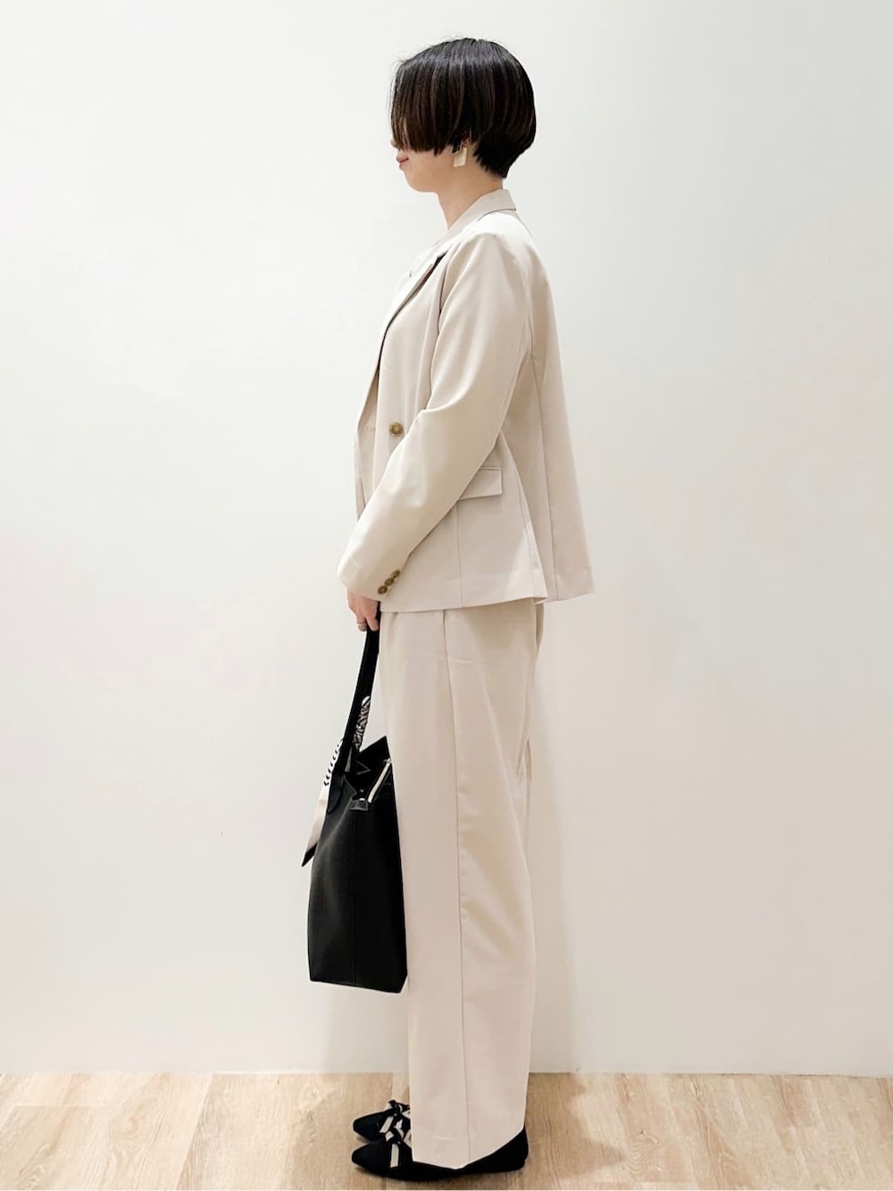 ホワイト系のTシャツ/カットソー、ブラック系のパンプス、ベージュ系のその他パンツを着用したレディースの春コーディネートの3枚目の写真