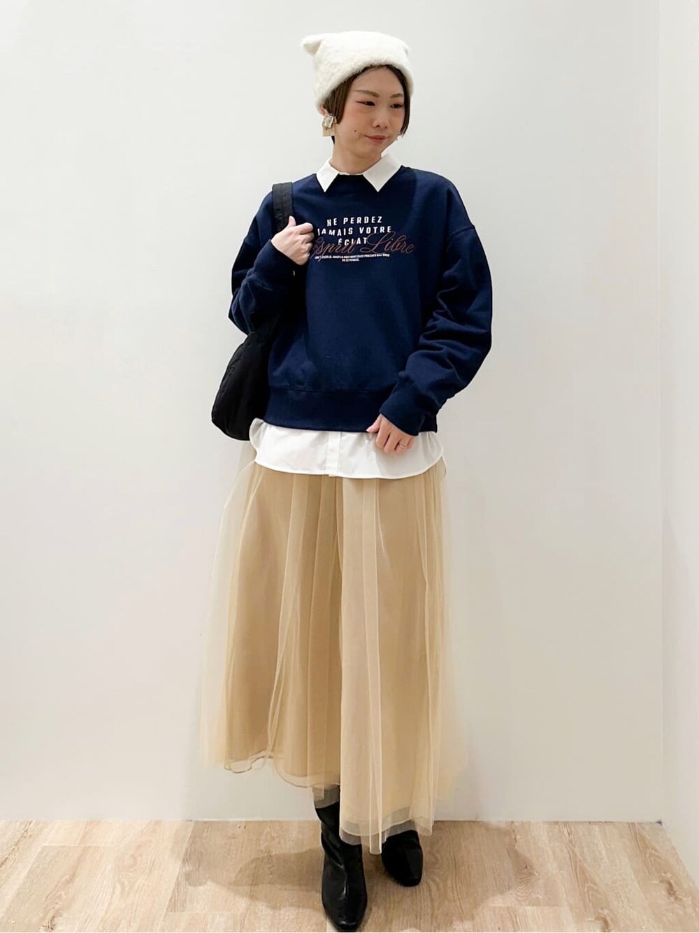 ブルー系のスウェット、ホワイト系のシャツ/ブラウス、ベージュ系のスカートを着用したレディースの冬コーディネートの5枚目の写真