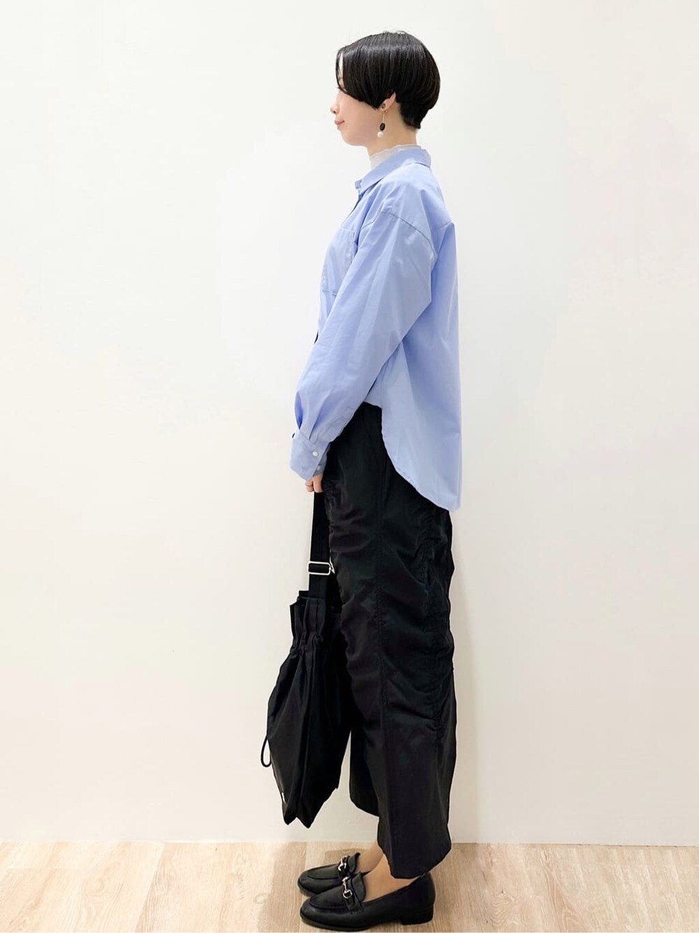 ブルー系のシャツ/ブラウス、ブルー系のTシャツ/カットソー、ブラック系のスカートを着用したレディースの春コーディネートの4枚目の写真