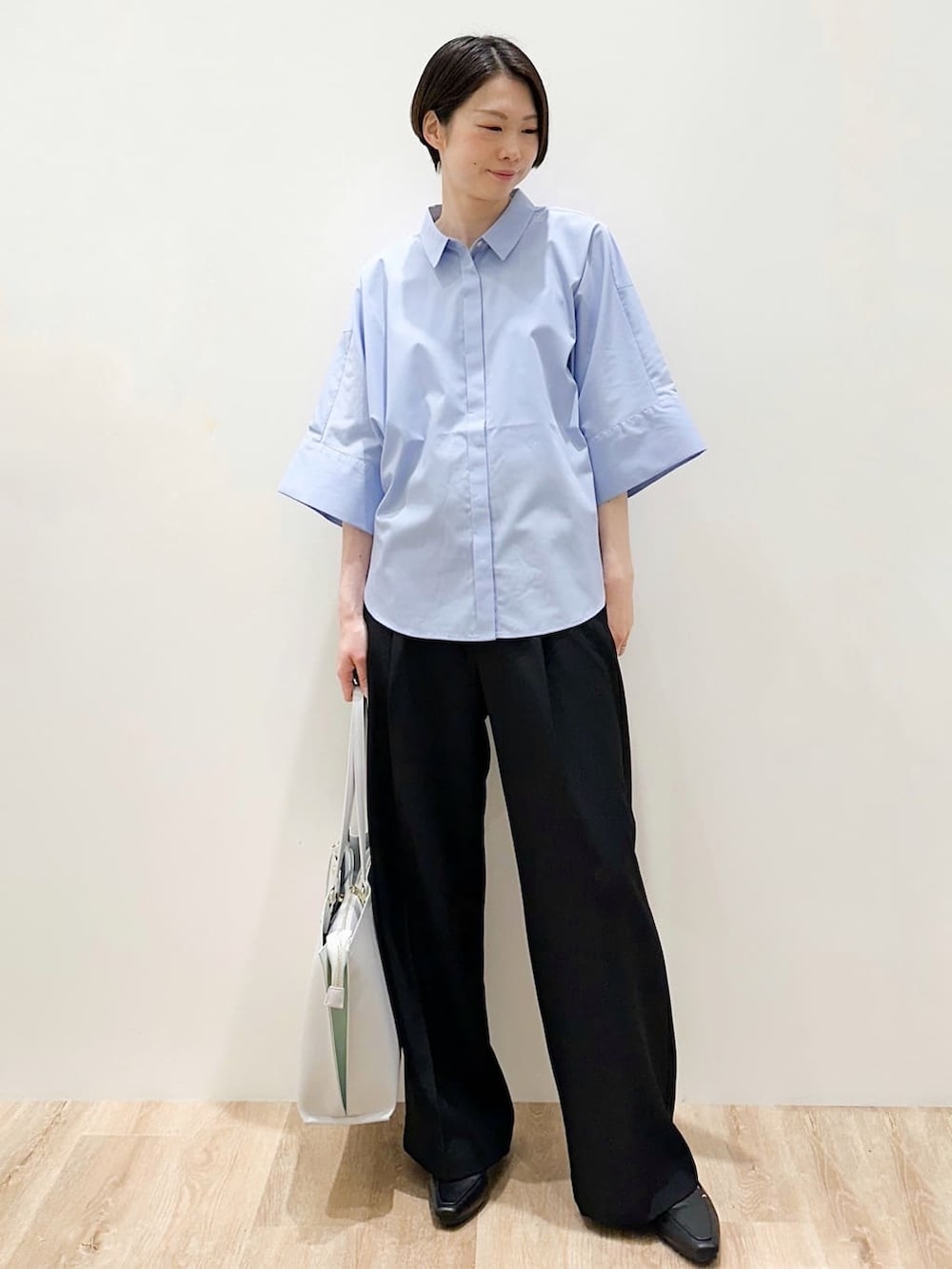 グレー系のトートバッグ、ブルー系のシャツ/ブラウス、ブラック系のその他パンツを着用したレディースの春コーディネートの6枚目の写真