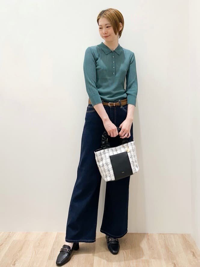 グリーン系のニット/セーター、ブルー系のデニムパンツ、ブラック系のトートバッグを着用したレディースの秋コーディネートの4枚目の写真