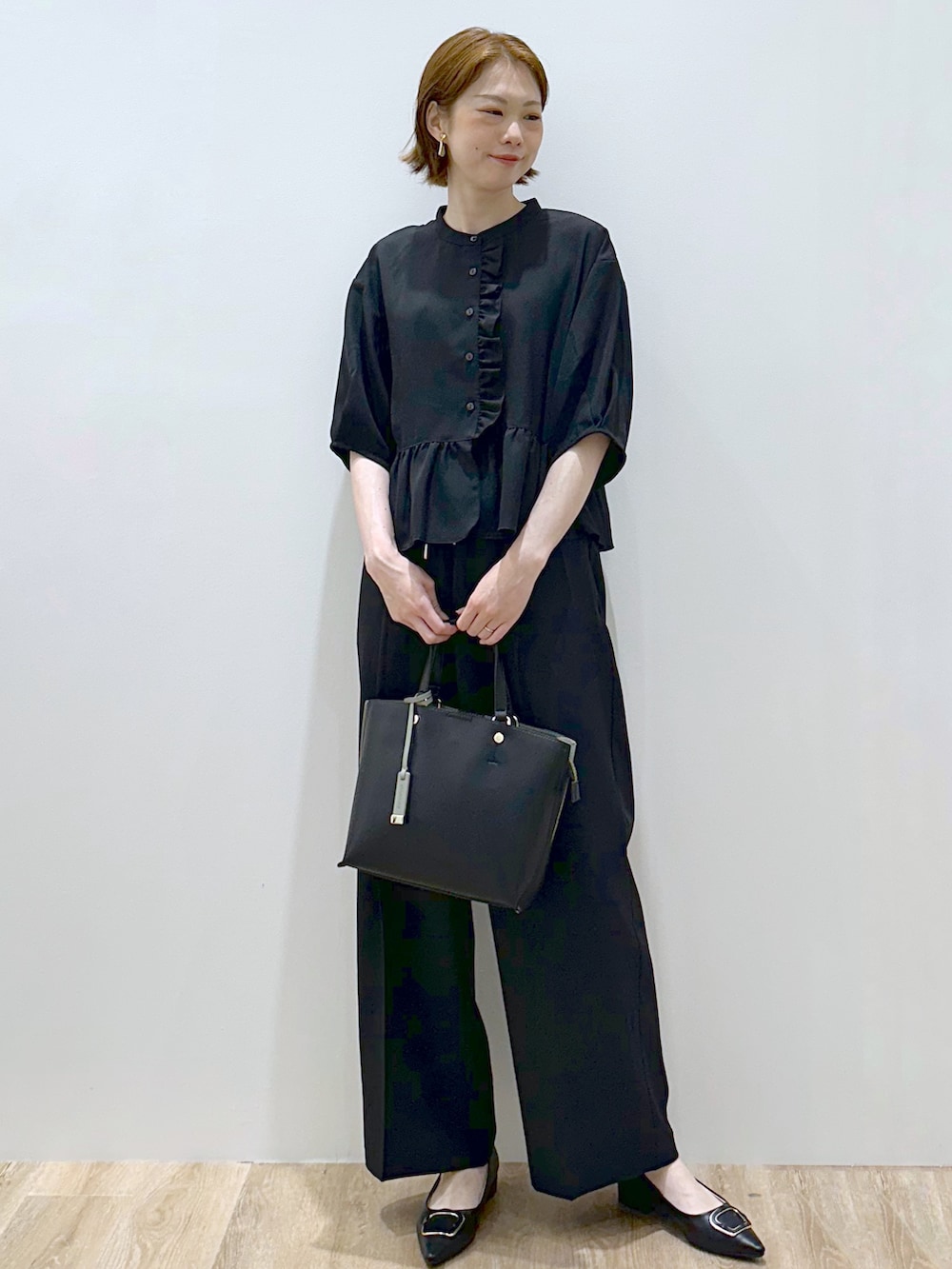 ブラック系のシャツ/ブラウス、ブラック系のその他パンツ、ブラック系のトートバッグを着用したレディースの秋コーディネートの7枚目の写真
