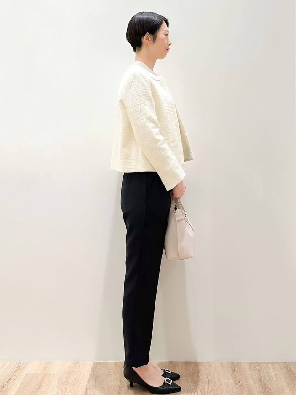 ピンク系のシャツ/ブラウス、ブラック系のその他パンツ、ホワイト系のノーカラージャケットを着用したレディースの冬コーディネートの3枚目の写真