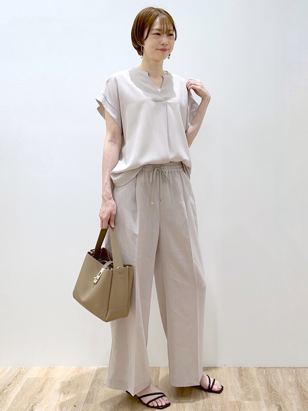 ベージュ系のシャツ/ブラウス、ベージュ系のその他パンツ、ブラウン系のトートバッグを着用したレディースの夏コーディネートの3枚目の写真