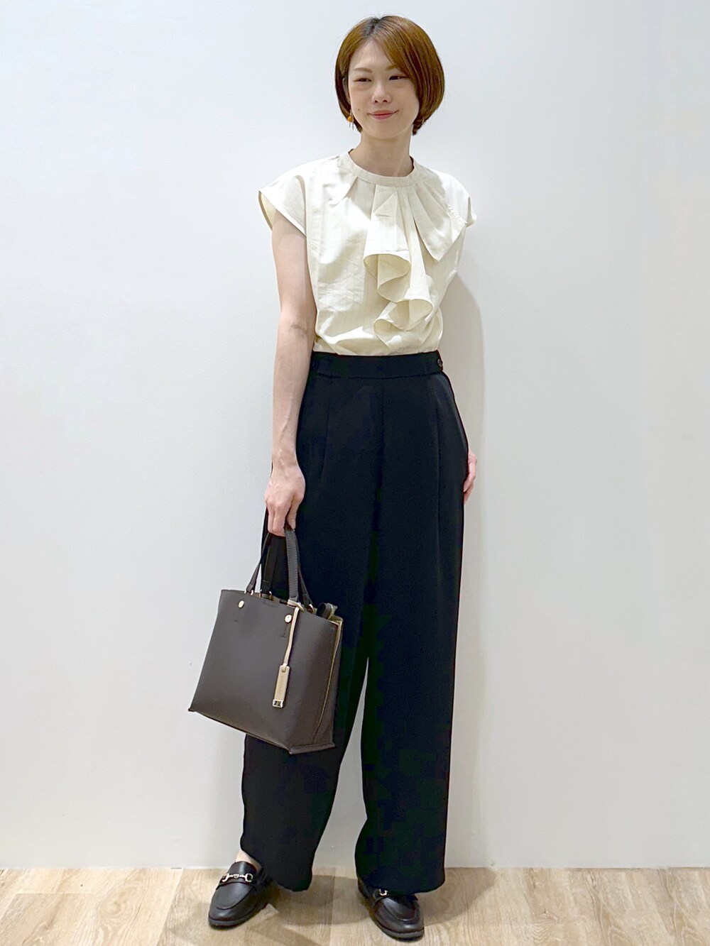 ベージュ系のシャツ/ブラウス、ブラック系のその他パンツ、ブラウン系のパンプスを着用したレディースの夏コーディネートの5枚目の写真