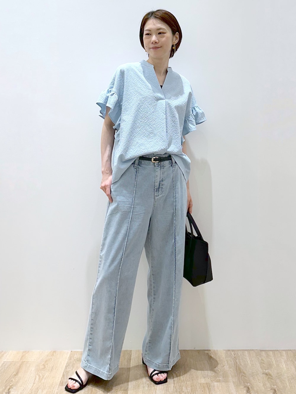 ブルー系のシャツ/ブラウス、ブラック系のタンクトップ、ブルー系のデニムパンツを着用したレディースの夏コーディネートの5枚目の写真