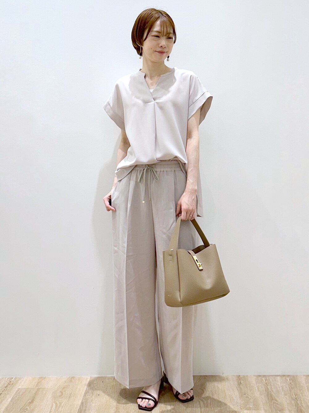 ベージュ系のシャツ/ブラウス、ベージュ系のその他パンツ、ブラウン系のトートバッグを着用したレディースの夏コーディネートの6枚目の写真