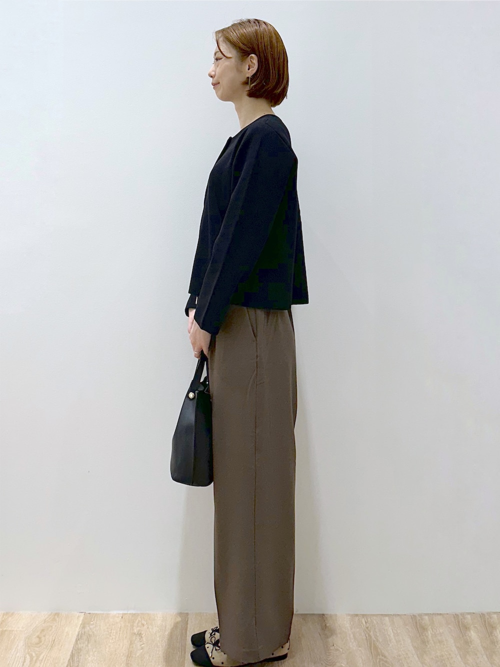 ブラック系のカーディガン/ボレロ、ブラウン系のその他パンツ、ブラック系のショルダーバッグを着用したレディースの秋コーディネートの3枚目の写真