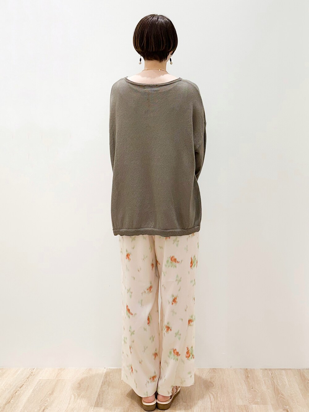 ブラウン系のニット/セーター、ホワイト系のタンクトップ、ホワイト系のその他パンツを着用したレディースの春コーディネートの4枚目の写真