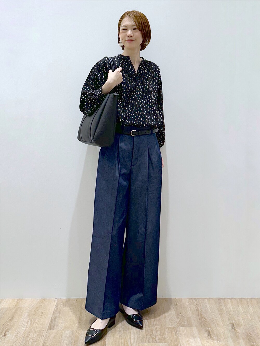 ブラック系のシャツ/ブラウス、ブルー系のその他パンツ、ブラック系のトートバッグを着用したレディースの秋コーディネートの2枚目の写真