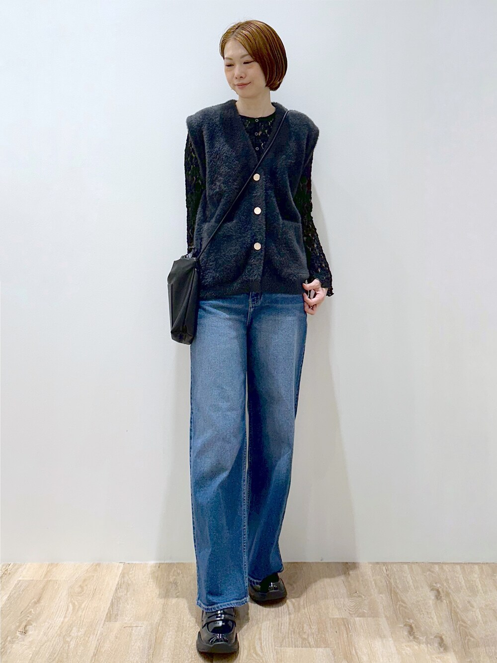 グレー系のニット/セーター、ブラック系のカーディガン/ボレロ、ブルー系のデニムパンツを着用したレディースの秋コーディネートの5枚目の写真