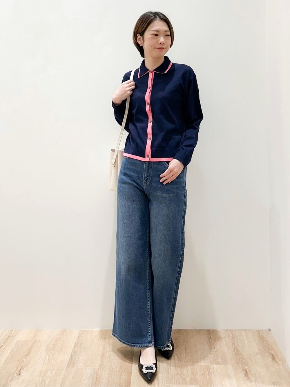 ブルー系のニット/セーター、ブルー系のデニムパンツ、ホワイト系のショルダーバッグを着用したレディースの冬コーディネートの4枚目の写真