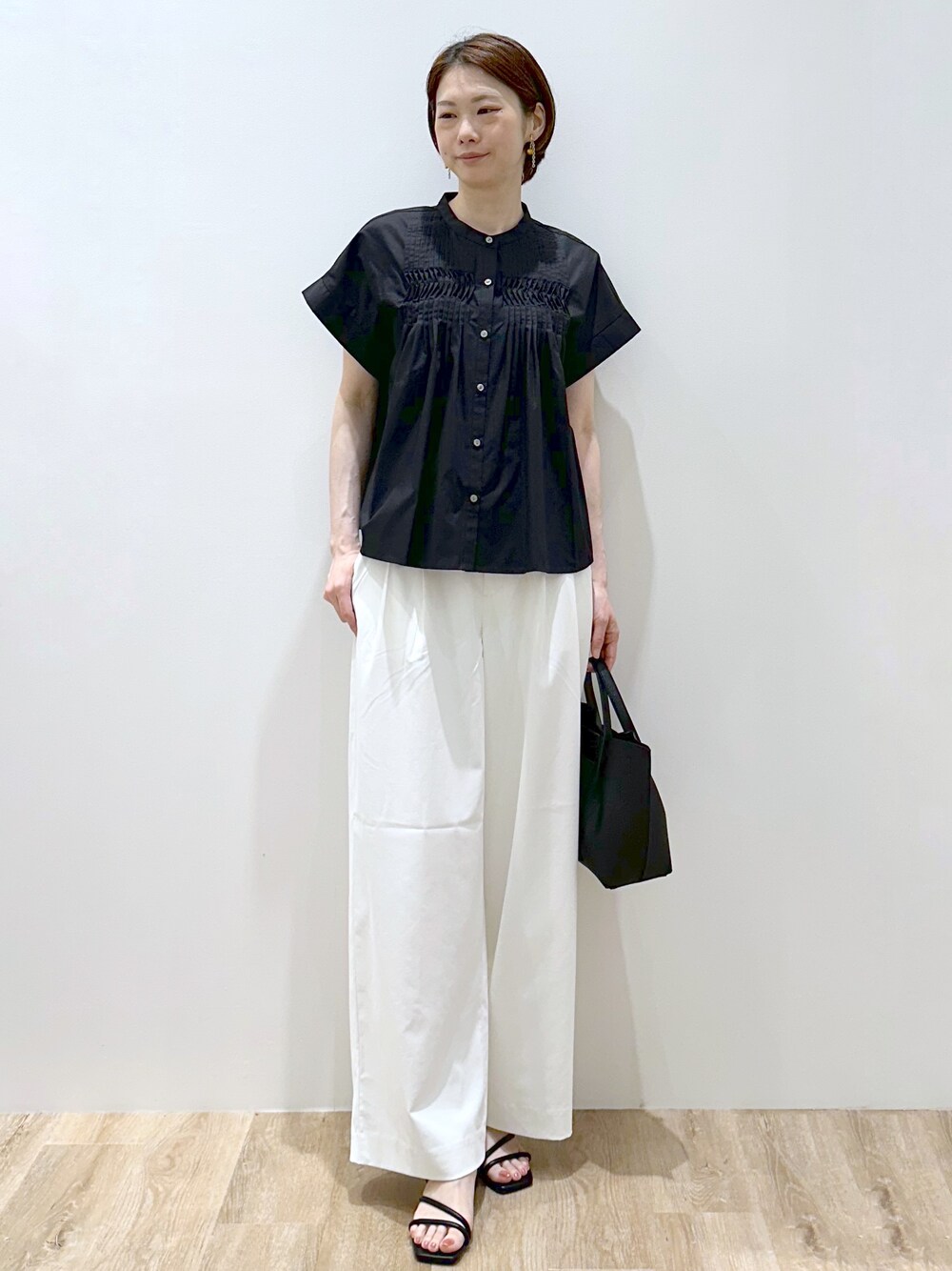 ブラック系のシャツ/ブラウス、ホワイト系のその他パンツ、ブラック系のトートバッグを着用したレディースの夏コーディネートの2枚目の写真