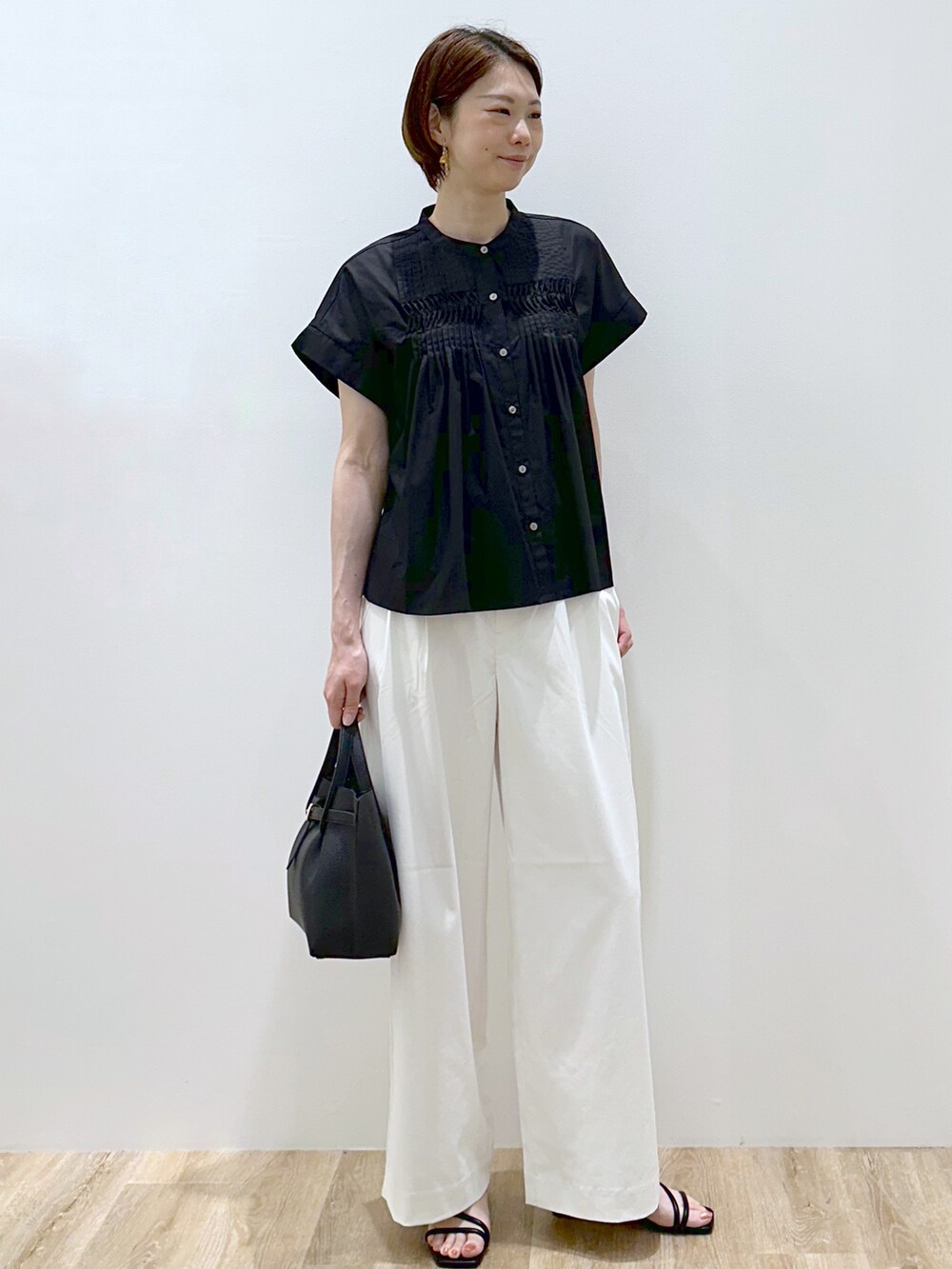 ブラック系のシャツ/ブラウス、ホワイト系のその他パンツ、ブラック系のトートバッグを着用したレディースの夏コーディネートの3枚目の写真