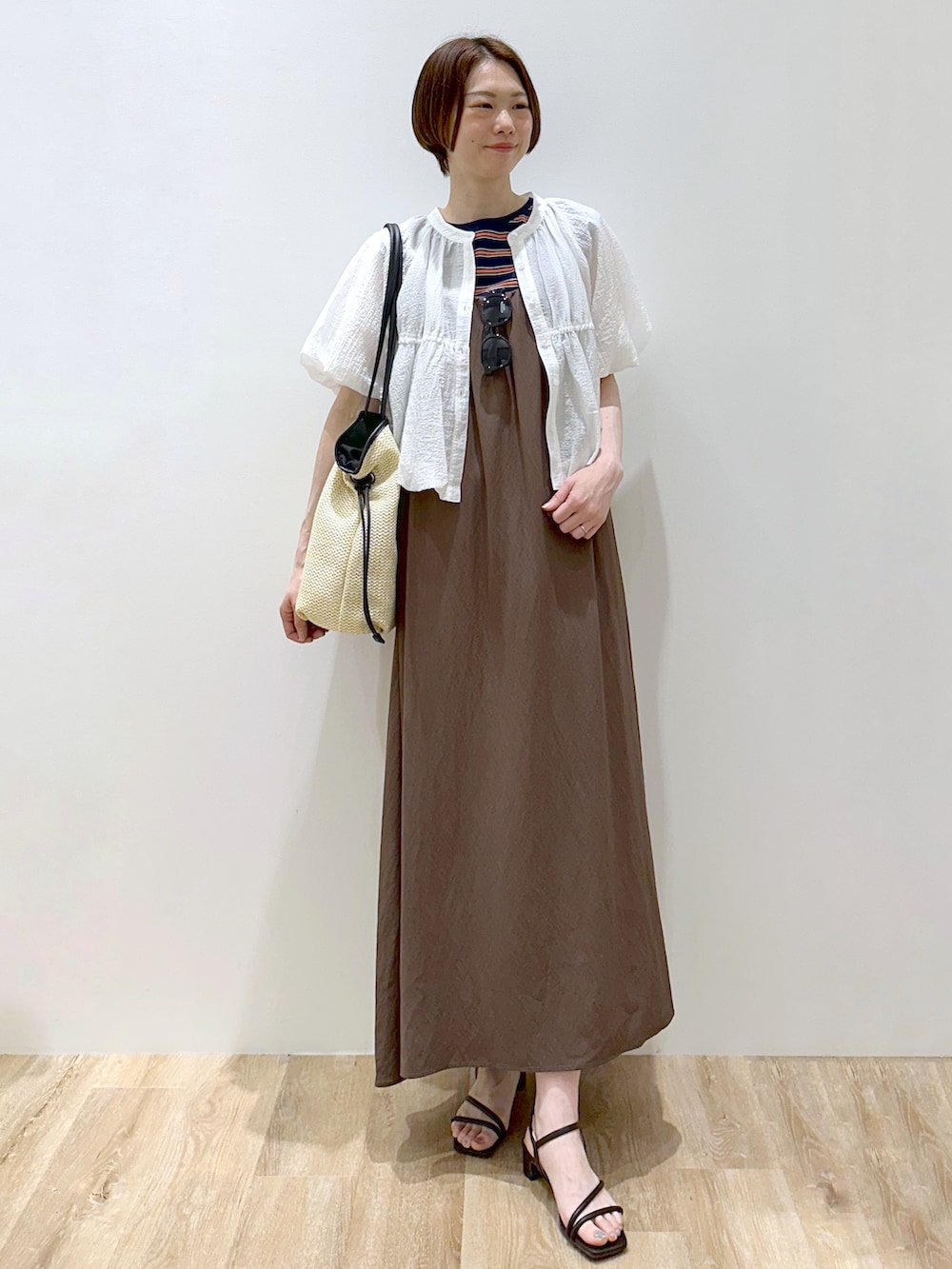 ブルー系のTシャツ/カットソー、ブラウン系のワンピース、ホワイト系のトートバッグを着用したレディースの春コーディネートの4枚目の写真