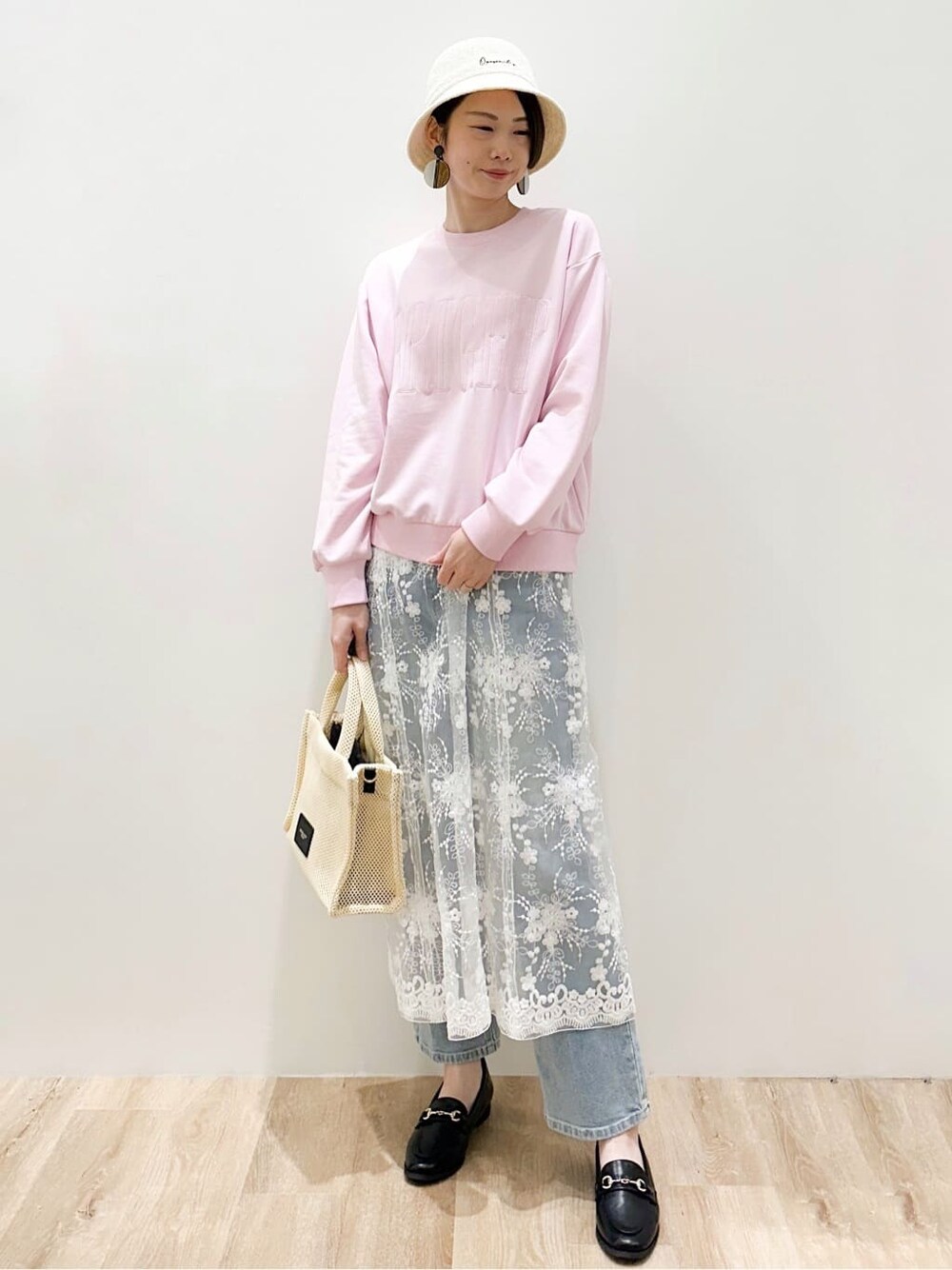 ブラック系のパンプス、ブルー系のデニムパンツ、ピンク系のTシャツ/カットソーを着用したレディースの春コーディネートの4枚目の写真