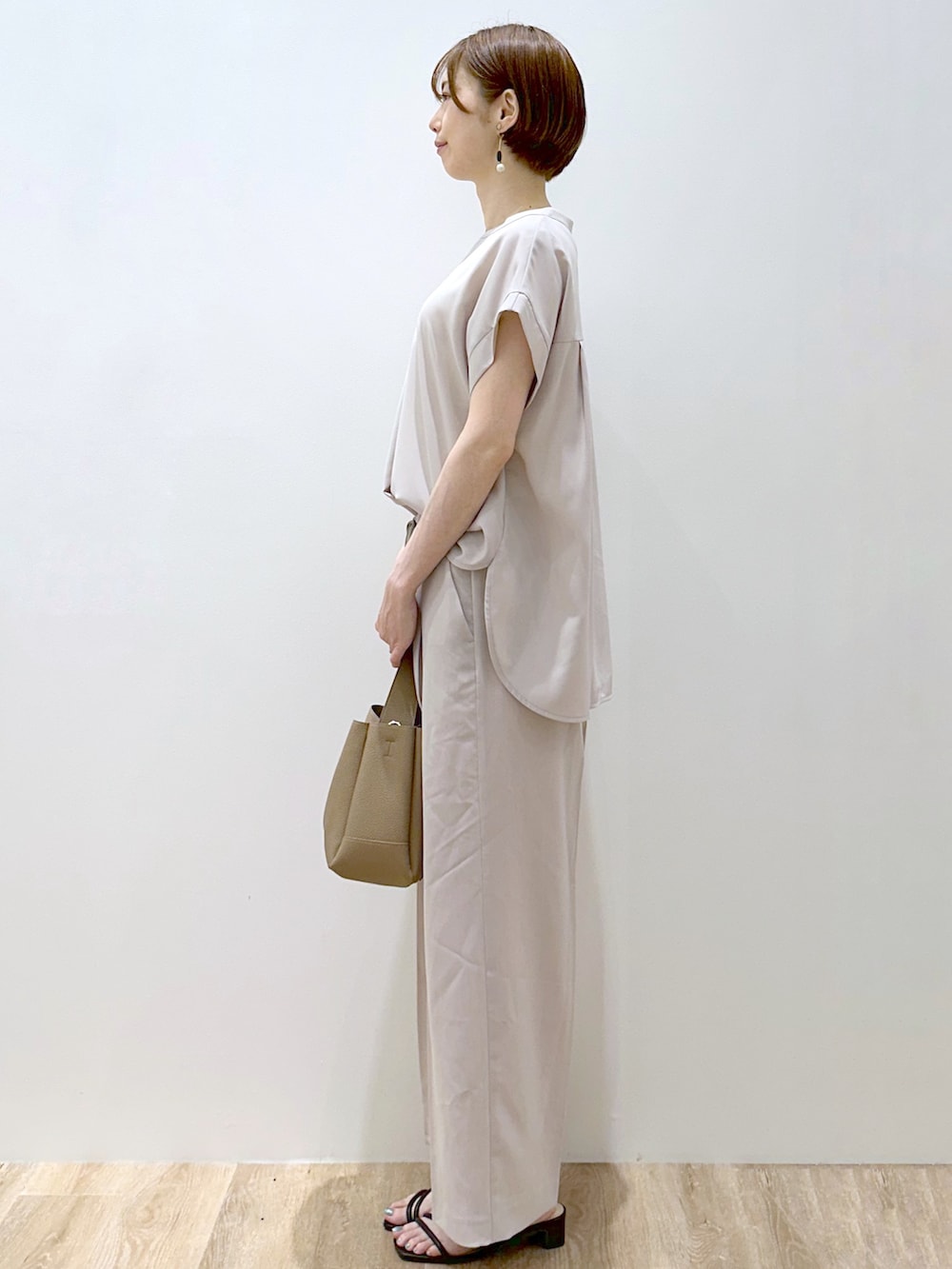 ベージュ系のシャツ/ブラウス、ベージュ系のその他パンツ、ブラウン系のトートバッグを着用したレディースの夏コーディネートの5枚目の写真