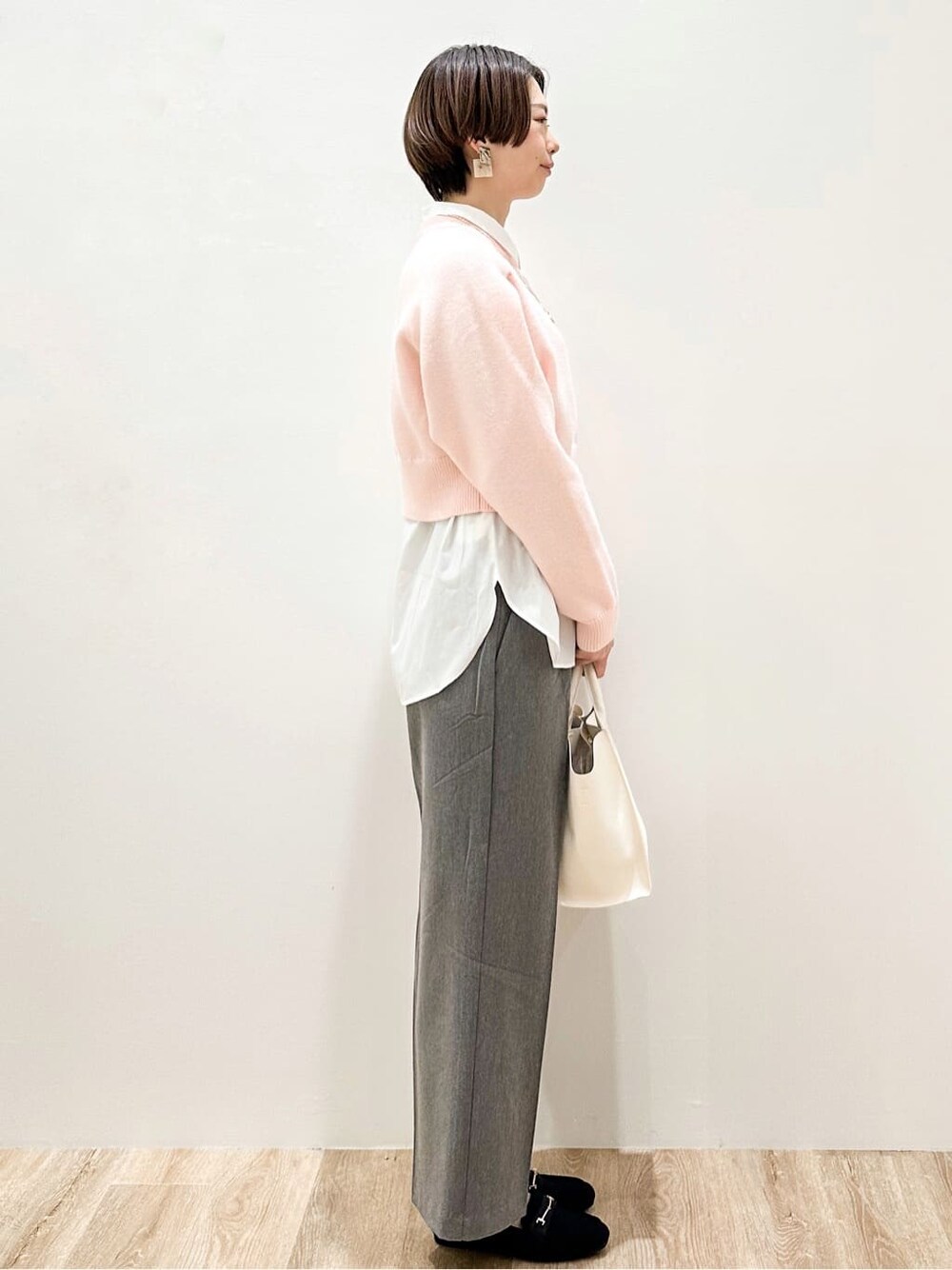 ピンク系のニット/セーター、ホワイト系のシャツ/ブラウス、グレー系のその他パンツを着用したレディースの冬コーディネートの3枚目の写真