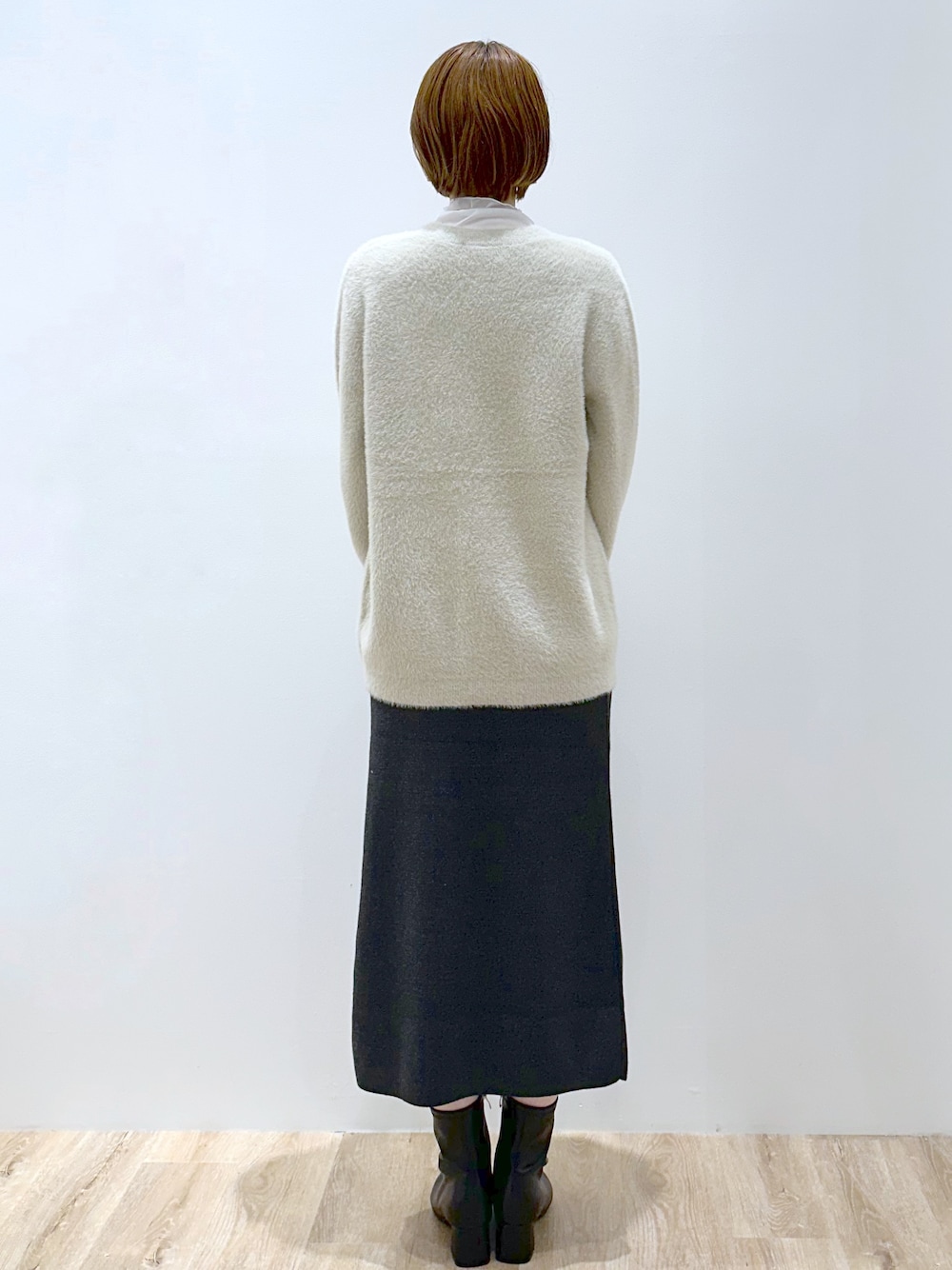 ベージュ系のカーディガン/ボレロ、ホワイト系のTシャツ/カットソー、グレー系のスカートを着用したレディースの秋コーディネートの4枚目の写真