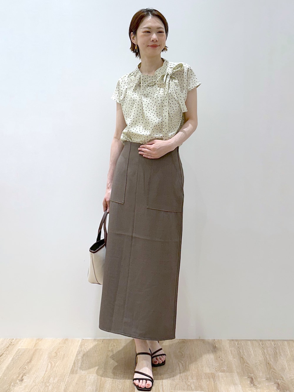 ブラウン系のカーディガン/ボレロ、ベージュ系のシャツ/ブラウス、ブラウン系のスカートを着用したレディースの夏コーディネートの7枚目の写真