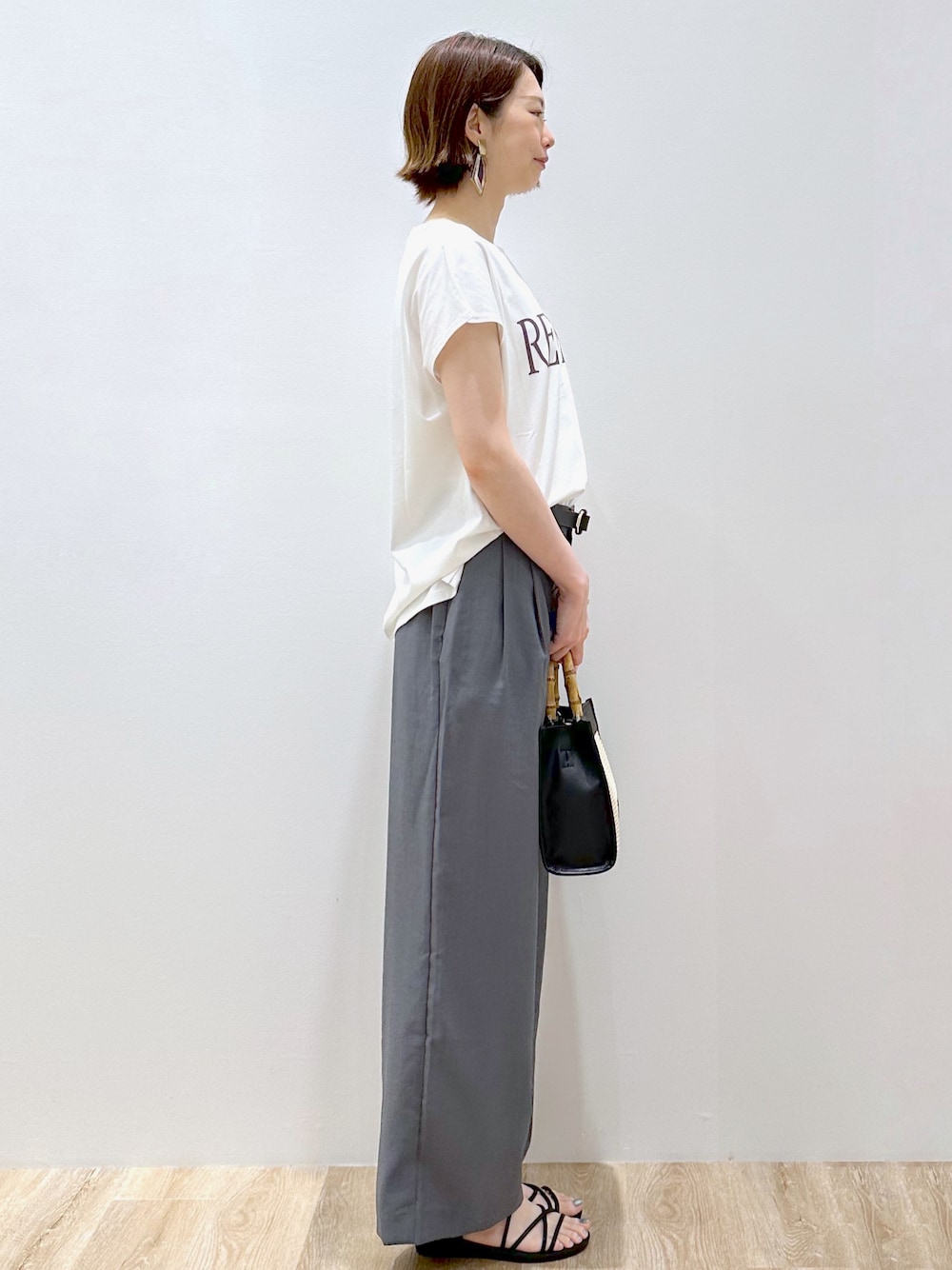 ホワイト系のTシャツ/カットソー、グレー系のその他パンツ、ブラック系のトートバッグを着用したレディースの夏コーディネートの2枚目の写真