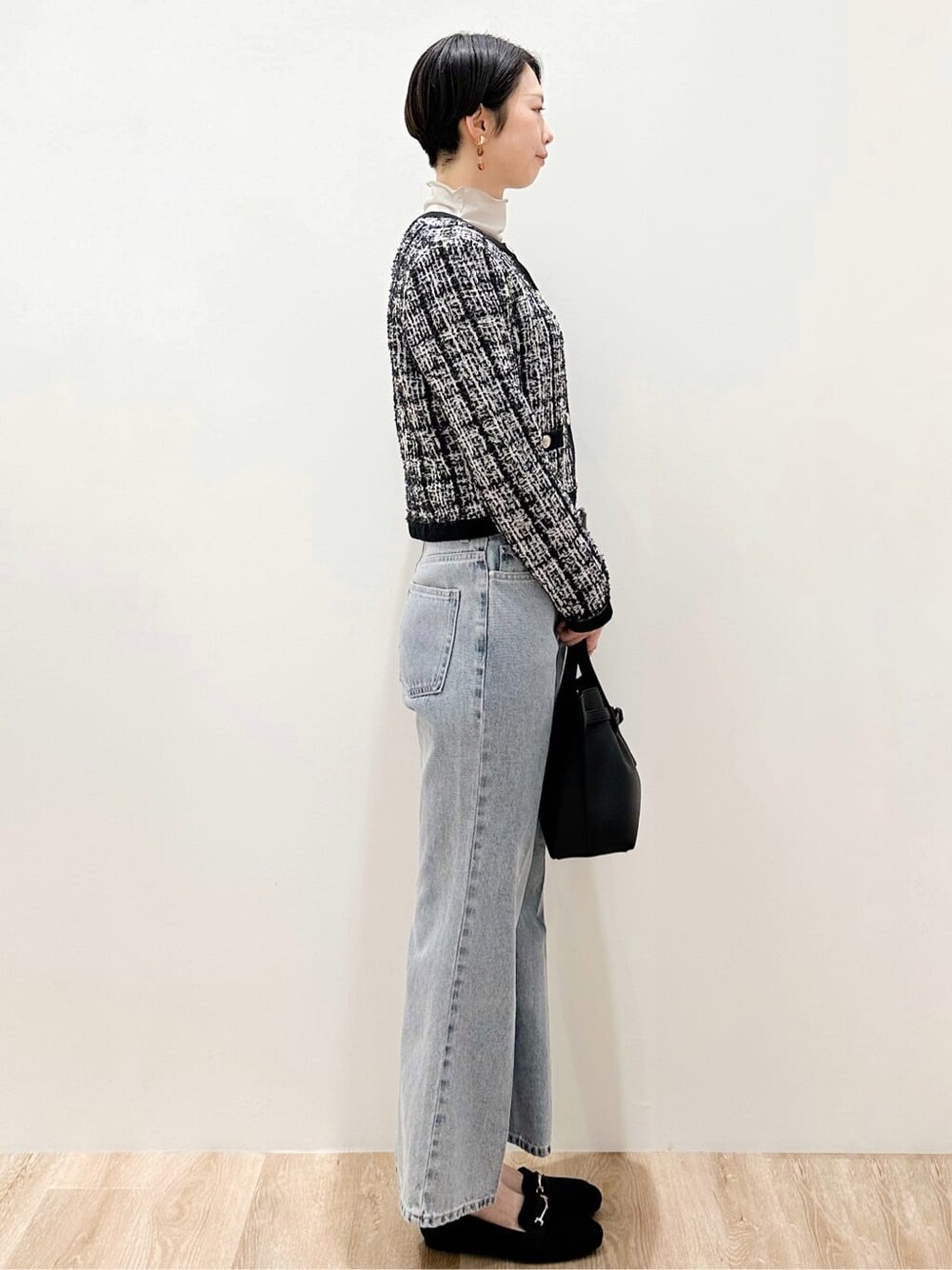 ブラック系のカーディガン/ボレロ、グレー系のTシャツ/カットソー、ブルー系のデニムパンツを着用したレディースの冬コーディネートの3枚目の写真