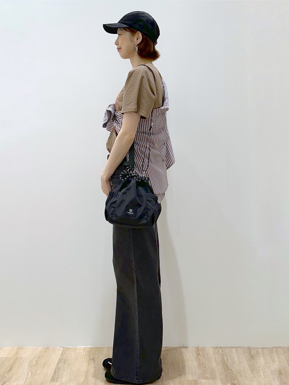 ブラウン系のシャツ/ブラウス、ブラウン系のTシャツ/カットソー、ブラック系のデニムパンツを着用したレディースの秋コーディネートの5枚目の写真