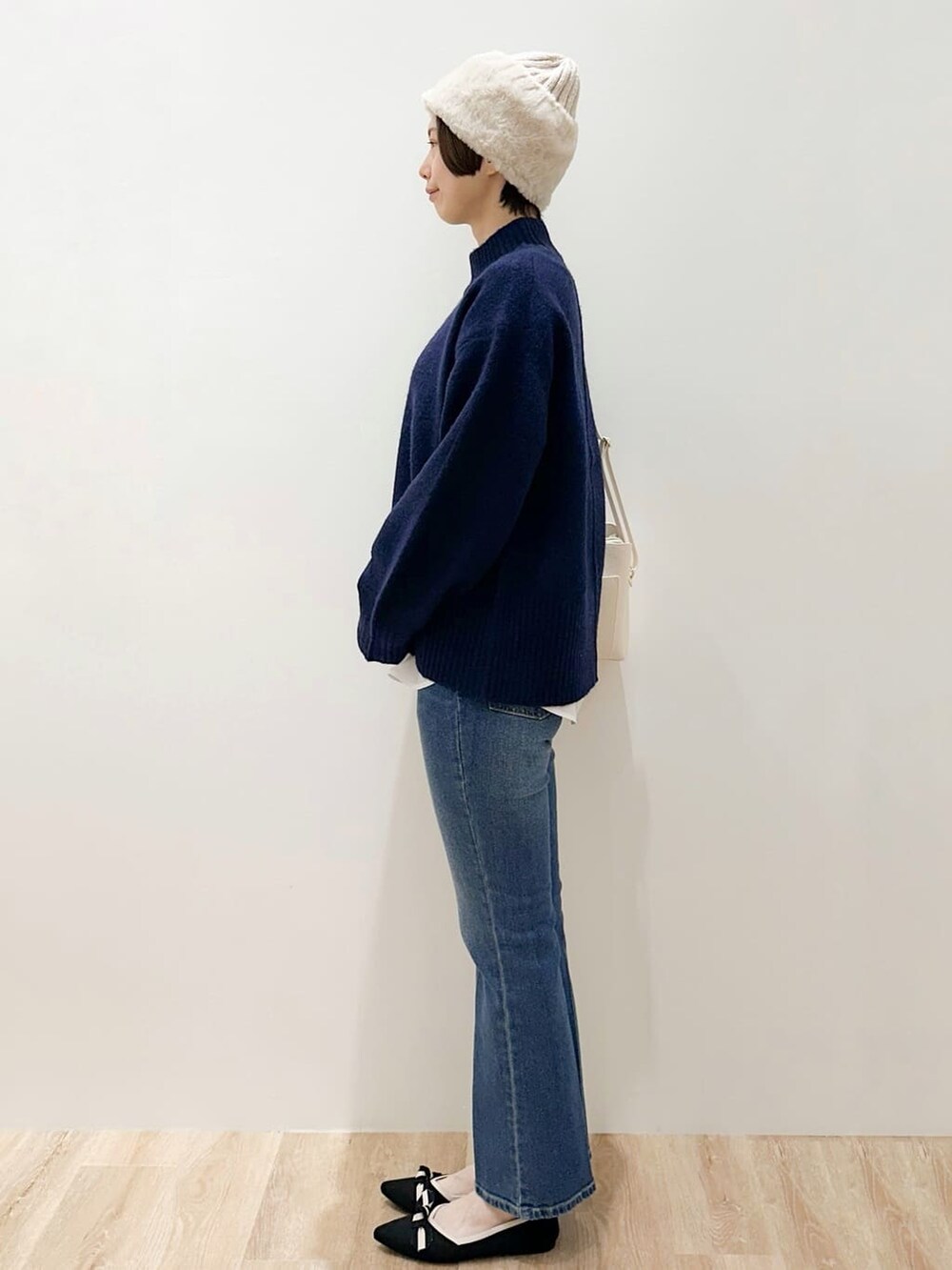 ブルー系のニット/セーター、ホワイト系のTシャツ/カットソー、ブルー系のデニムパンツを着用したレディースの冬コーディネートの2枚目の写真