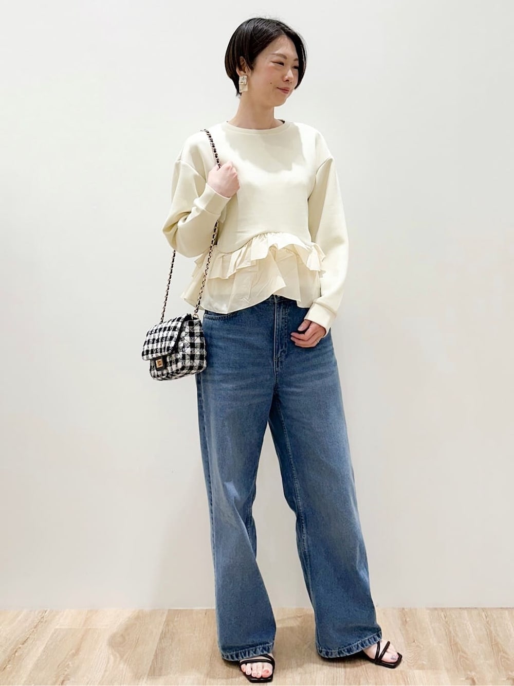 ブルー系のデニムパンツ、イエロー系のTシャツ/カットソー、ブラック系のサンダルを着用したレディースの春コーディネートの2枚目の写真
