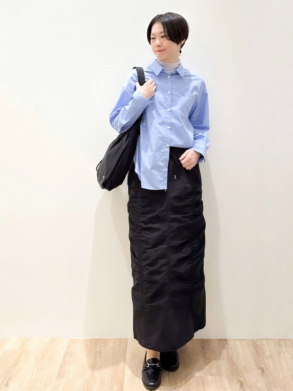 ブルー系のシャツ/ブラウス、ブルー系のTシャツ/カットソー、ブラック系のスカートを着用したレディースの春コーディネートの5枚目の写真