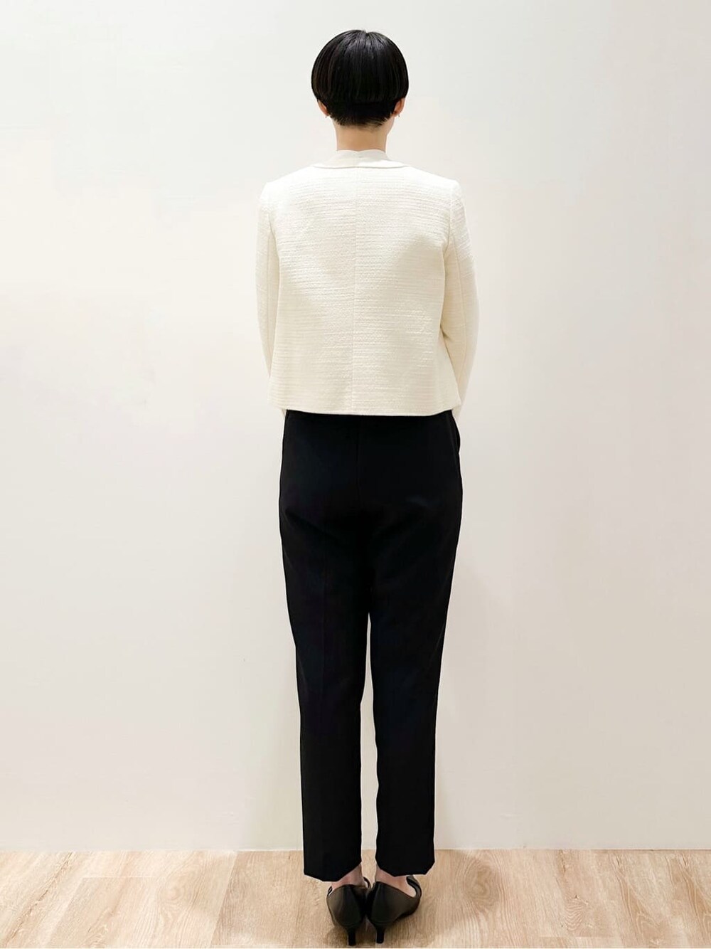ピンク系のシャツ/ブラウス、ブラック系のその他パンツ、ホワイト系のノーカラージャケットを着用したレディースの冬コーディネートの4枚目の写真