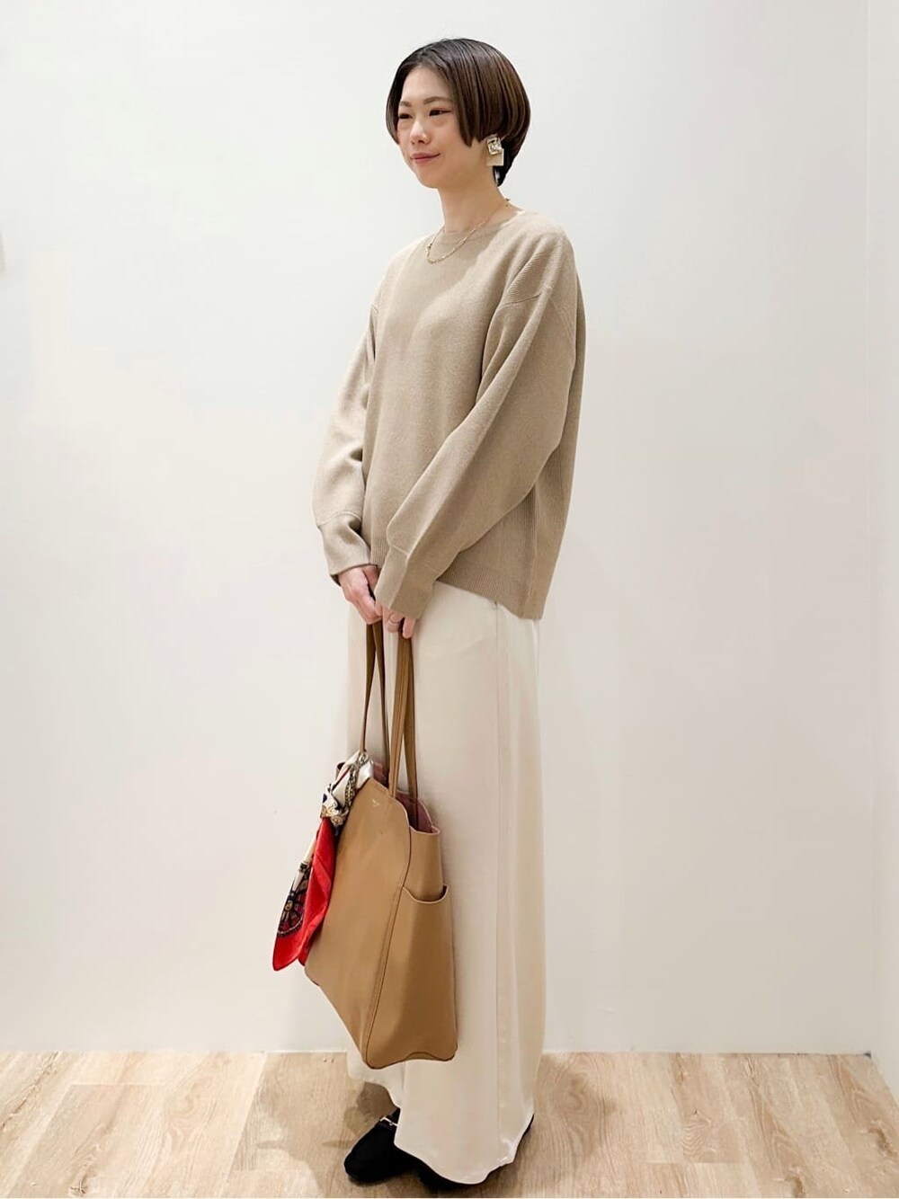 ベージュ系のニット/セーター、ホワイト系のその他パンツ、ベージュ系のトートバッグを着用したレディースの冬コーディネートの2枚目の写真