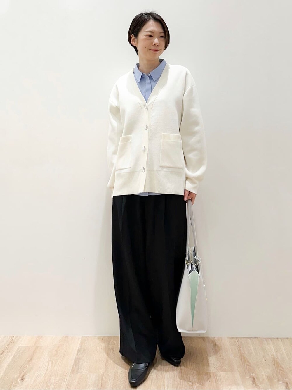 グレー系のトートバッグ、ブルー系のシャツ/ブラウス、ブラック系のその他パンツを着用したレディースの春コーディネートの2枚目の写真