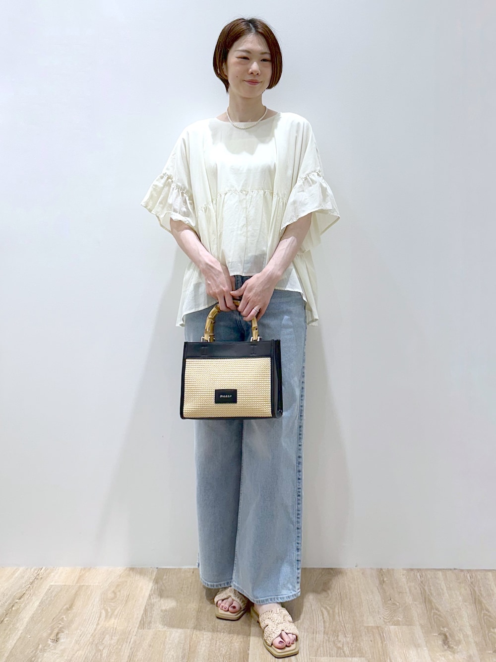 ホワイト系のシャツ/ブラウス、ブルー系のデニムパンツ、ブラック系のトートバッグを着用したレディースの春コーディネートの6枚目の写真