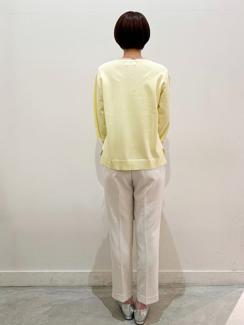 イエロー系のニット/セーター、ホワイト系のその他パンツ、ホワイト系のショルダーバッグを着用したレディースの春コーディネートの4枚目の写真
