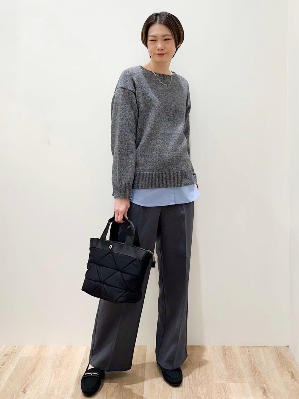 グレー系のニット/セーター、ブルー系のTシャツ/カットソー、グレー系のその他パンツを着用したレディースの冬コーディネートの2枚目の写真