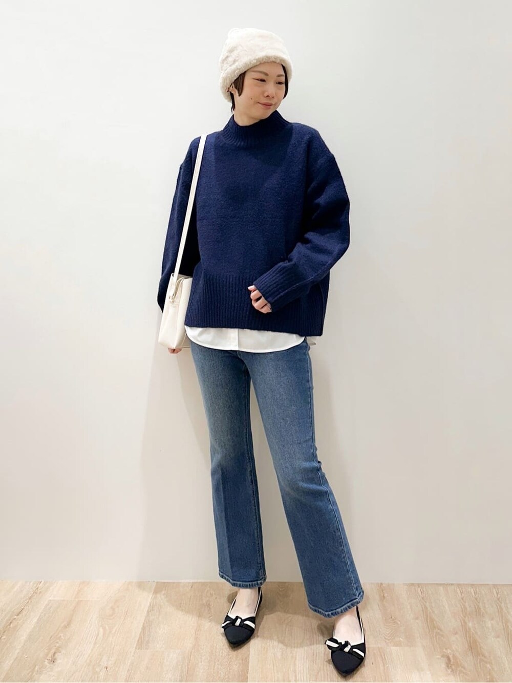 ブルー系のニット/セーター、ホワイト系のTシャツ/カットソー、ブルー系のデニムパンツを着用したレディースの冬コーディネートの7枚目の写真