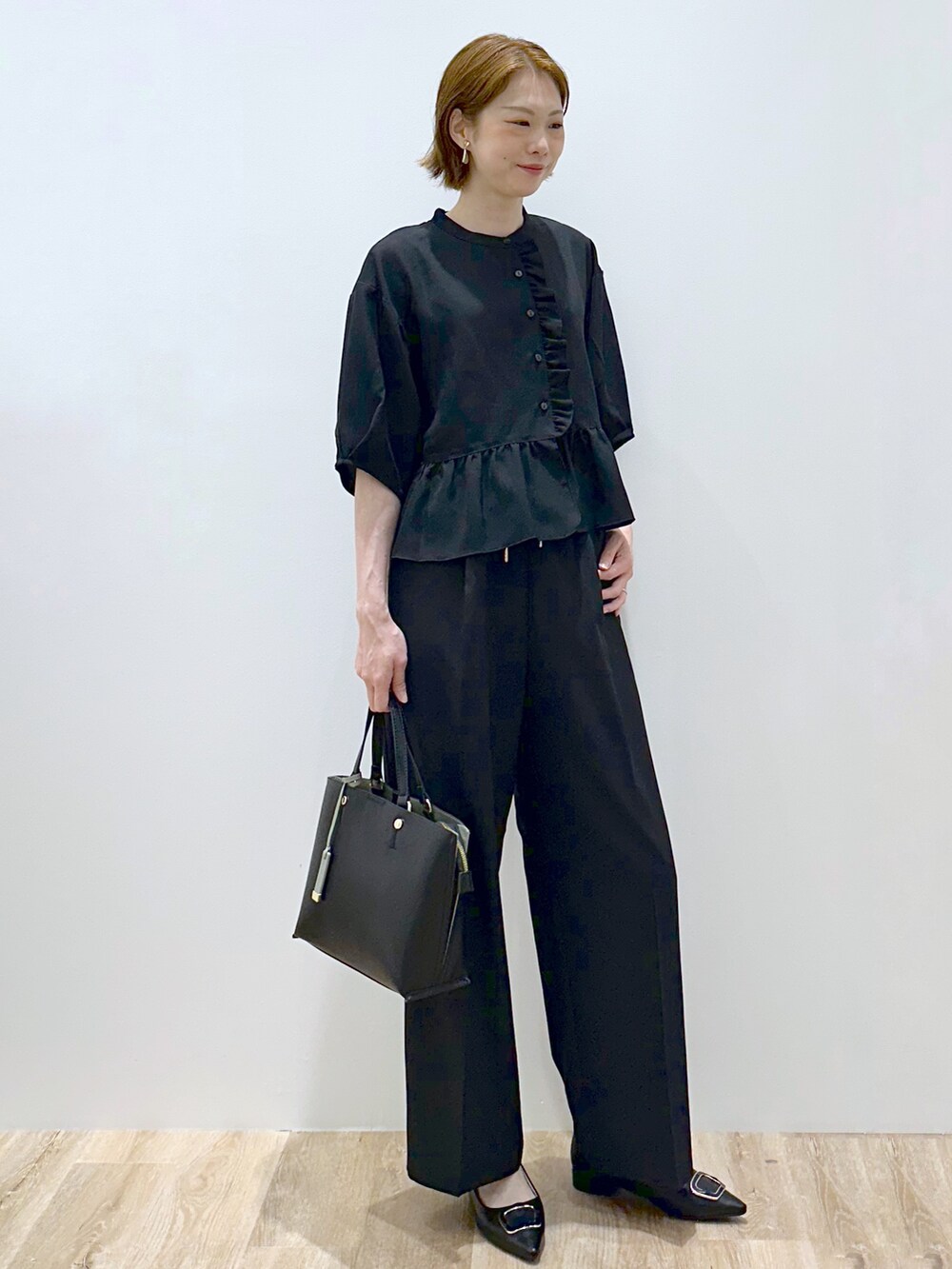 ブラック系のシャツ/ブラウス、ブラック系のその他パンツ、ブラック系のトートバッグを着用したレディースの秋コーディネートの3枚目の写真